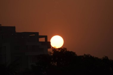 Sunrisr siluetli binanın tepesinde.