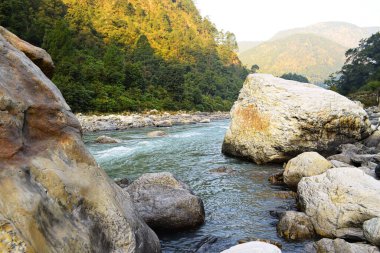 Bhagirathi nehri yatağındaki kayalar sabah parıltısıyla, uttarkashi, uttarakhand, Hindistan 'la çevrili.