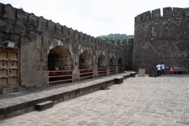daulatabad, maharashtra, Hindistan-Ağustos 31, 2025: Daulatabad kale avlusu taş duvarlar, bir kule, tarihi topların sergilendiği, turistlerin keşfettiği