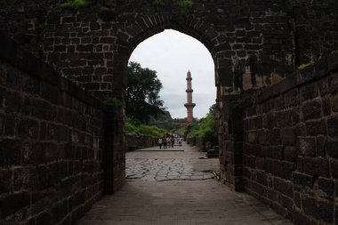 daulatabad, maharashtra, Hindistan - 31 Ağustos 2025: Daulatabad Kalesi 'ndeki taş bir geçitten görülen' chand minar 'kulesi, Lindo İslami mimarisi ve tarihi ihtişam sergileniyor.