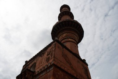 indo islamic tower near Aurangabad. red sandstone structure with arched niches attracts tourists at its base, maharashtra, india