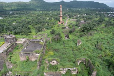 Ufuk boyunca uzanan antik bir daulatabad kalesinin kalıntıları, yemyeşil ve yuvarlanan tepelerle çevrili, dramatik bir tarihi eser yaratıyor.