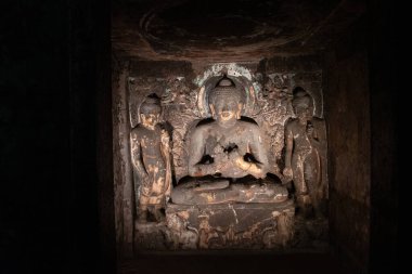 Ajanta mağaraları, maharashtra, india- 30 Ağustos 2025: 7. Mağara mabedine oyulmuş hizmetli figürleriyle çevrili 'dharmachakra mudra' da oturan budha