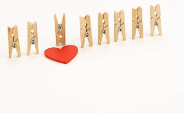 Olağanüstü aşk ilişkileri konsepti. Mandallar ve kırmızı tahta kalp.. 