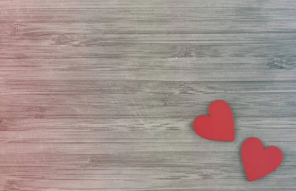 Dois corações de madeira vermelha no fundo de madeira subiu gradiente azul — Fotografia de Stock