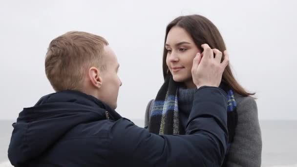 Älskar unga par. Killen rör försiktigt flickornas hår, ung söt flicka ler tittar i hans ögon — Stockvideo