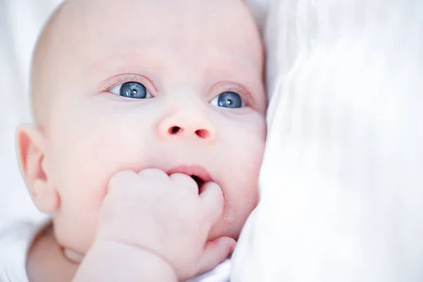 Close-up portret van zuigeling pasgeboren baby zuigen zijn vuist Stockfoto