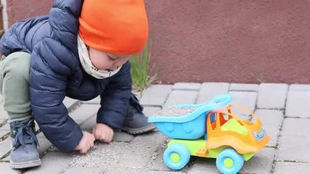 Kleiner Junge spielt draußen mit Spielzeugauto — Stockvideo