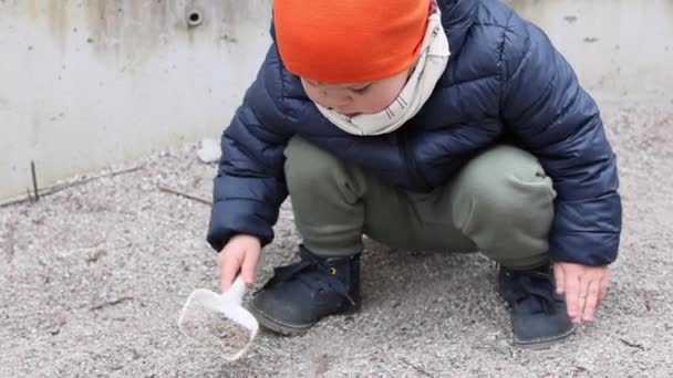 3-letni chłopiec bawi się czerpakiem i zabawką na zewnątrz — Wideo stockowe