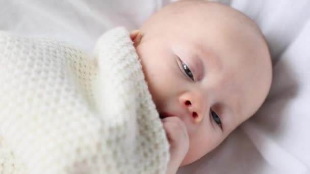 Baby spädbarn ansikte visas från vit filt — Stockvideo