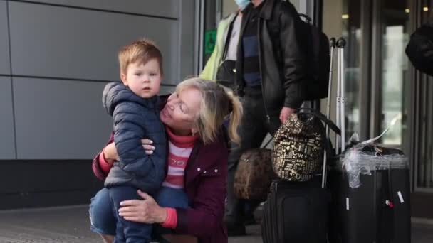Бабушка старшая женщина встречает внука в аэропорту — стоковое видео
