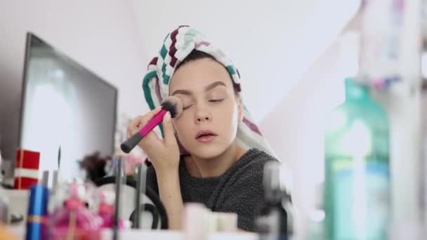Young woman making herself make-up with special brush — Wideo stockowe