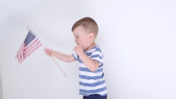 Happy child kid boy jumping on the bed with American flag — Video Stock