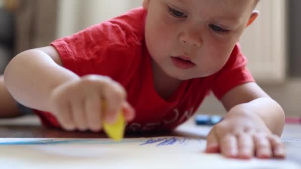 一个小孩躺在地板上，用蜡笔画的肖像的特写 — 图库视频影像