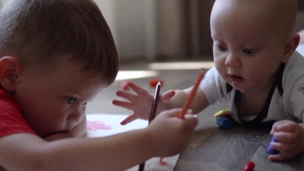 Dva malí kluci hrající kresbu ležící na podlaze, koncepce rodinného životního stylu — Stock video