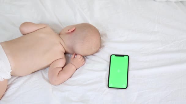 spací dítě kojenec na bílých prostěradlech se zelenou obrazovkou chromakey zařízení 