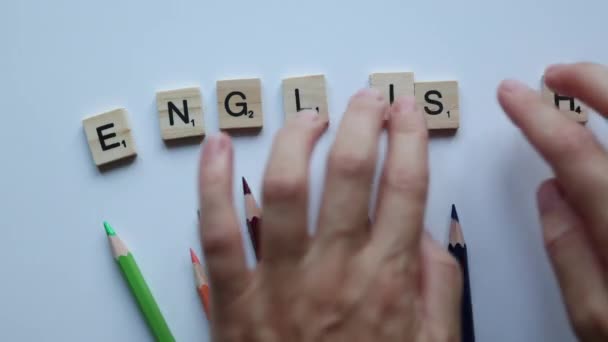 Слово "англійська складаючись з кусочок блоків букв". Дитяча освіта повертається до школи. — стокове відео