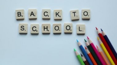 back to school written in wooden letters with colorful pencils and medicine mask on white background