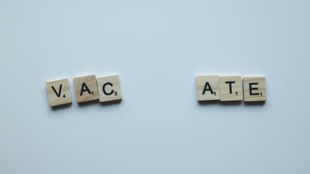 Hand composing word vaccinate on white background. vaccine stop covid coronavirus concept — Stockvideo