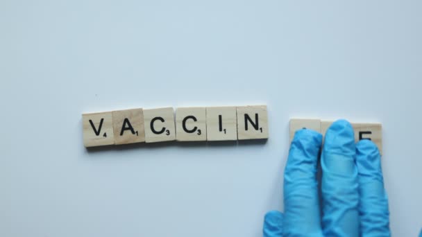 Hand composing word vaccinate on white background. vaccine stop covid coronavirus concept — Vídeos de Stock