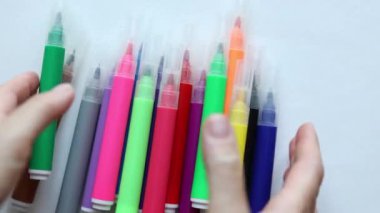 Beyaz arka planda çok renkli işaretler hareket ediyor. Okula dönüş çizim malzemesi konsepti 