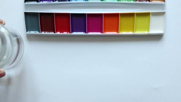 Przygotowanie dłoni do lekcji sztuki lub malarstwa szkła akwareli wodnej farby pędzle na białym tle. koncepcja kształcenia — Wideo stockowe