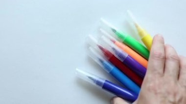 Beyaz arka planda çok renkli işaretler hareket ediyor. Okula dönüş çizim malzemesi konsepti 