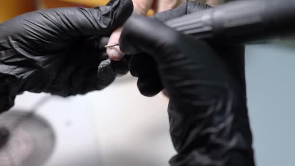 Manikúra mistr v černých rukavicích pracuje se speciální vrtačkou čištění nehtů cuticle z prstu klienta — Stock video