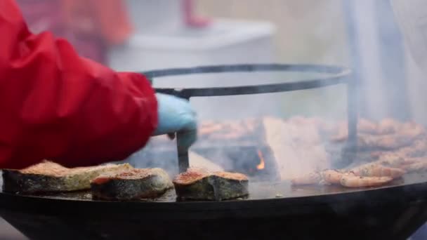 Street seafood salmon fish and shrimps cooked in round barbecue grill with open fire inside — Stock Video