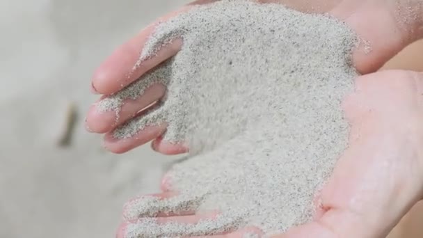 Biały piasek spadający przez palce dłoni kobiety — Wideo stockowe