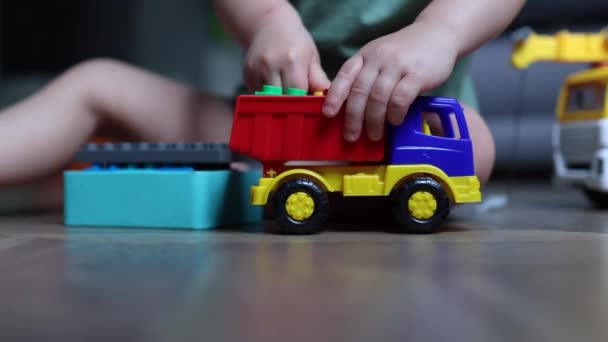 Bambino bambino mani giocare con giocattolo pista mettere blocchi di plastica all'interno — Video Stock