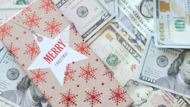 Caixa de presente vermelha de Natal no fundo de notas de dólar americano. evento feriado dom conceito — Vídeo de Stock