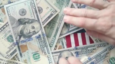 Eller ABD bayrağından 100 dolarlık banknotları taşıyor. Amerikan hayat parası iş dünyası finansal konsepti