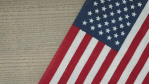 Американский флаг на столе и долларовые купюры банкноты падают бросая покрывая его — стоковое видео
