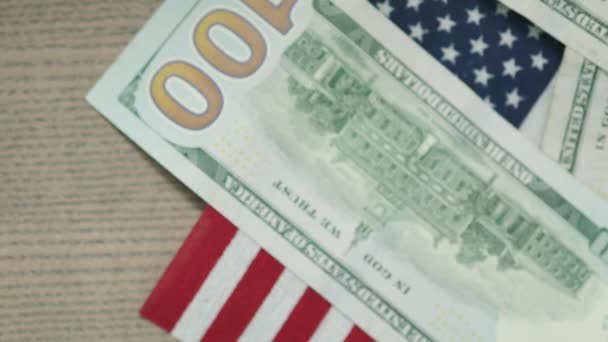 Американський прапор на столі і долари падають на нього, покриваючи символ США. — стокове відео