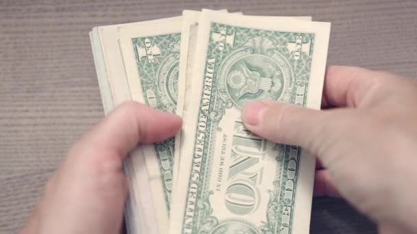 Mão feminina contando economias de dinheiro dos EUA em um fundo de mesa de madeira. ganhos finanças riqueza salário conceito — Vídeo de Stock