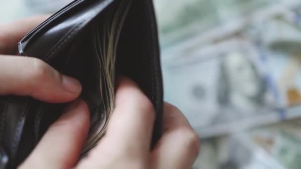 Mano tirando fuori banconote dollaro banconote contanti dalla borsa portafoglio nero — Video Stock