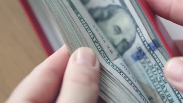Handen vertellen stapel van honderd dollar biljetten in een rode geschenkdoos — Stockvideo