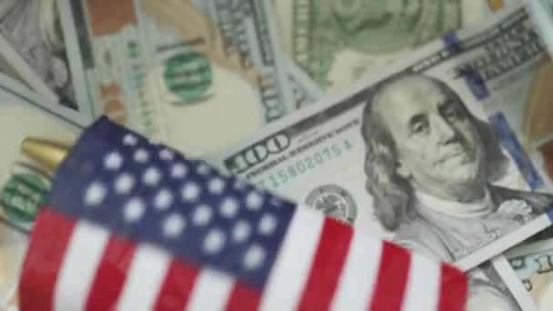 Символ американского флага падает на фоне стодолларовых купюр — стоковое видео