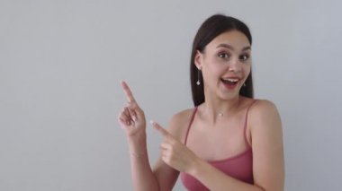 Güzel genç dişiler parmakları ve el sallayarak mutlu sevinçle işaret ediyor.