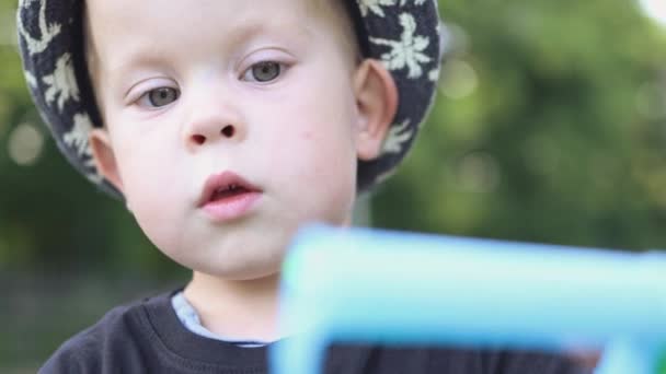 Portret poważnego dziecka chłopiec kapelusz zabawy z niebieskim uchwytem i sznurek liny — Wideo stockowe