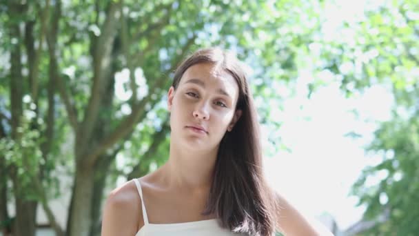 Portret ładna młoda brunetka kobieta z długimi włosami i białe góry zielone drzewa — Wideo stockowe