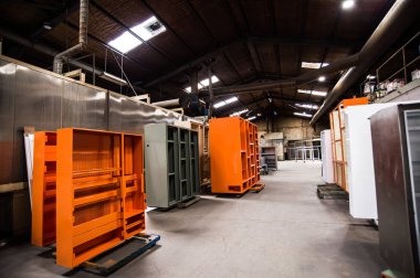 Atölyenin endüstriyel iç mimarisi. Kompresör tabancasıyla boyanmış metal ürünler. Üretimde toz kaplama işlemi.