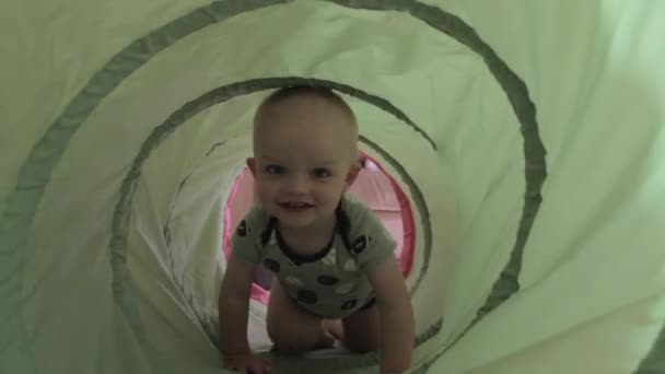 Jongen spelen in een groene tunnel — Stockvideo