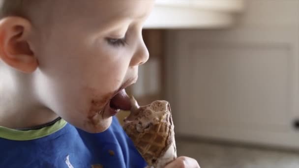 Niño comiendo un helado de chocolate cono — Vídeos de Stock