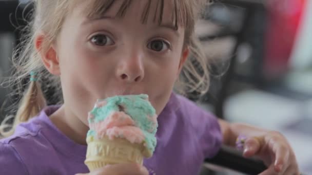 Une fille manger de la crème glacée et faire des visages — Video