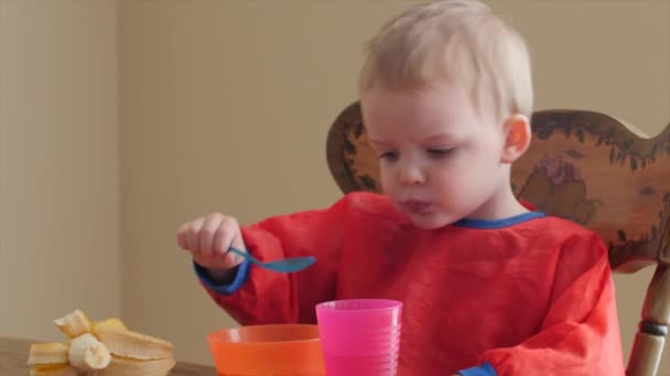 Boy eats banana and cereal for breakfast — Stock Video