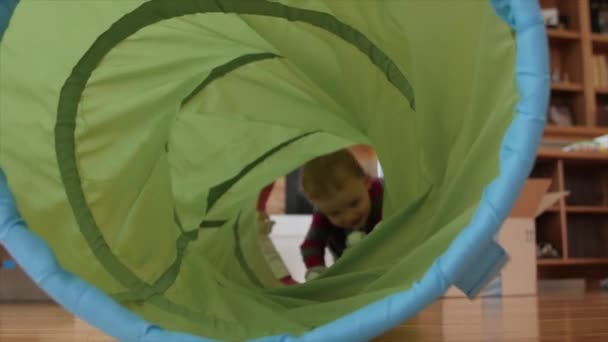 Boy crawls through a play tunnel — Stock Video