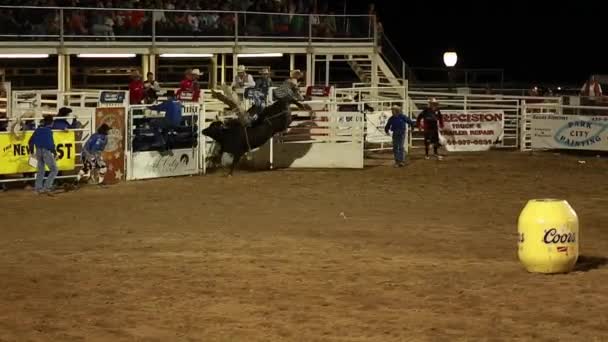 Ein Cowboy auf einem Bullen beim Rodeo in Zeitlupe — Stockvideo