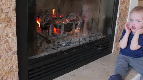 Niño de pie frente a la chimenea — Vídeos de Stock